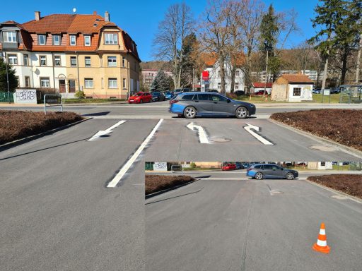 Weiße Richtungspfeile auf Asphalt markieren Fahrspuren und vorgeschriebene Fahrtrichtungen an einer Ein- und Ausfahrt.