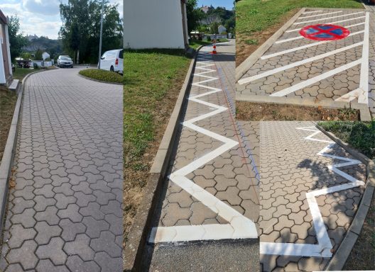 Weiße Zickzack-Markierung und Sperrfläche mit Halteverbot auf gepflasterter Verkehrsfläche im Außenbereich