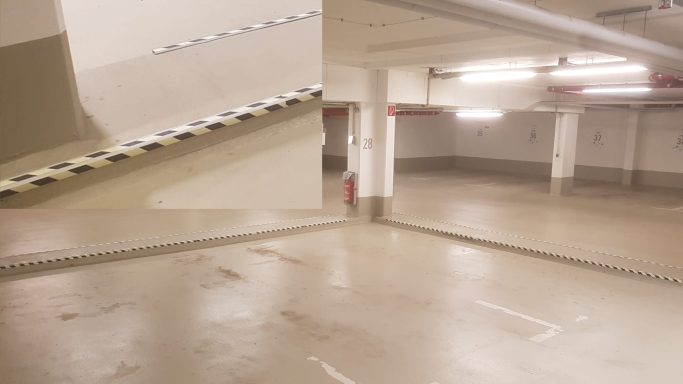 Gelb-schwarze Stolperkantenmarkierung an erhöhten Kanten im Parkhaus verbessert die Sichtbarkeit und Sicherheit.